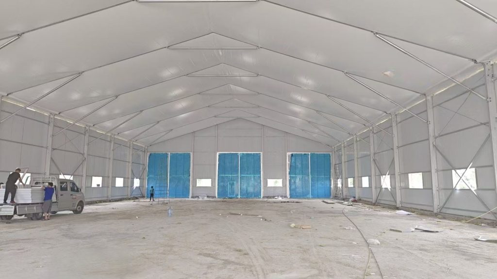 An insulated aluminum arch sports tent with sandwich panel walls in a winter setting