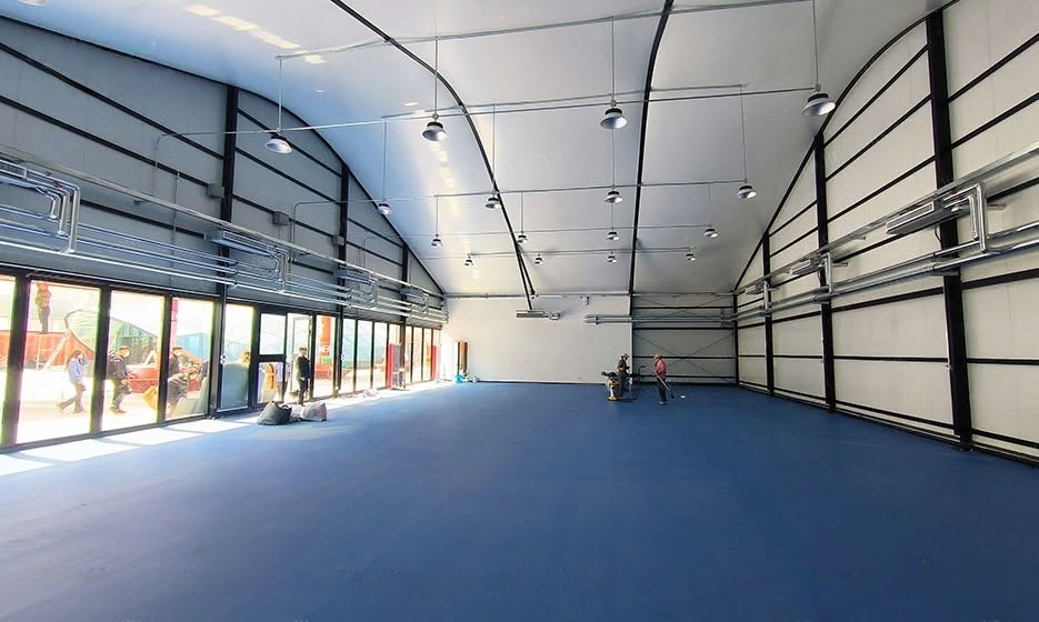 An insulated aluminum arch sports tent with sandwich panel walls in a winter setting