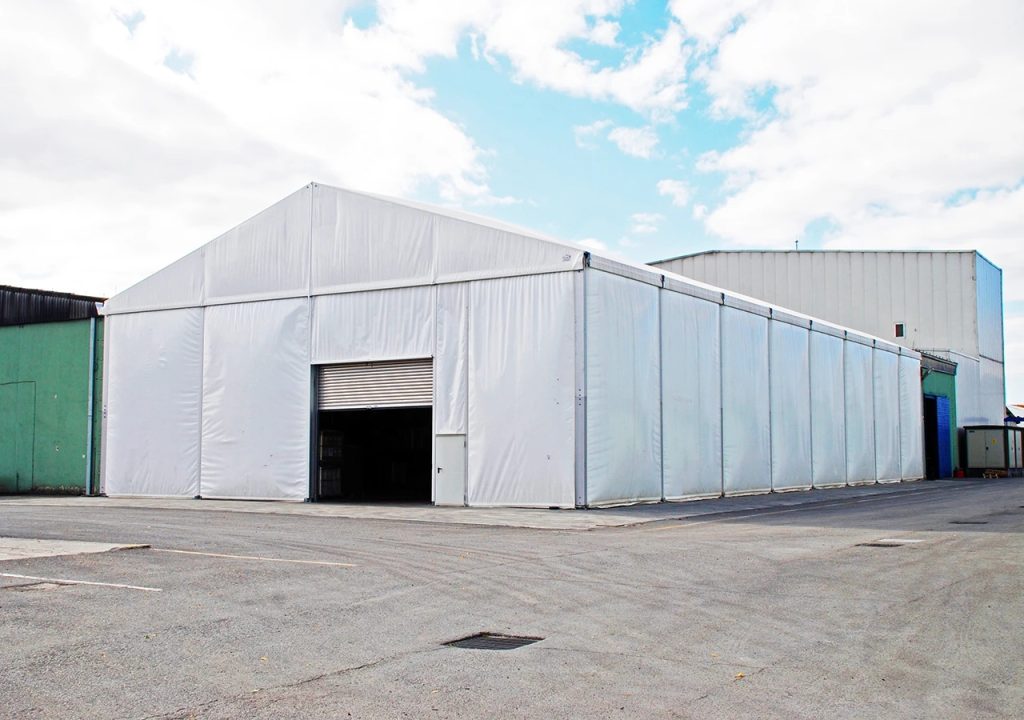 Large aluminum frame storage tent placed on concrete, white PVC roof and sidewalls